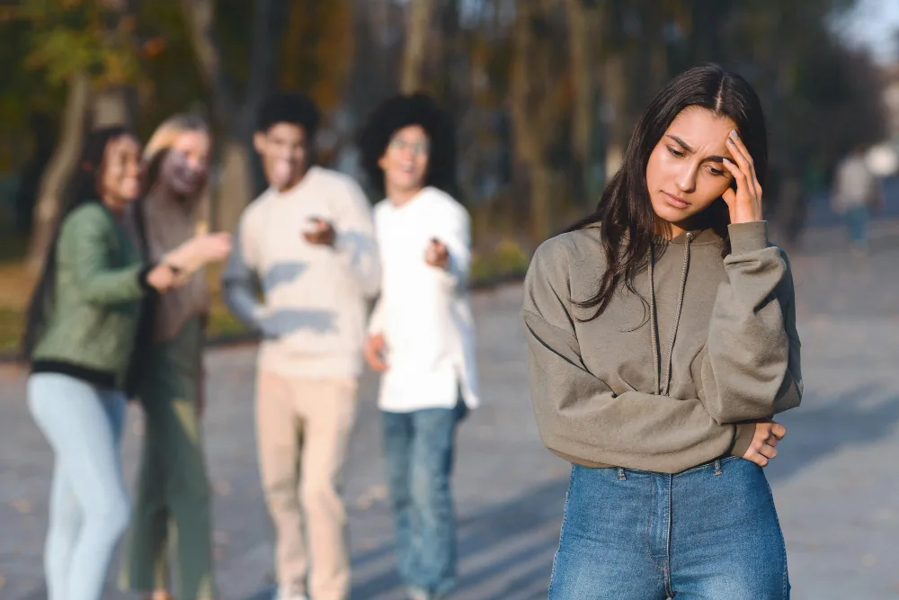 Woman appearing emotionally disconnected while surrounded by other people in a social setting