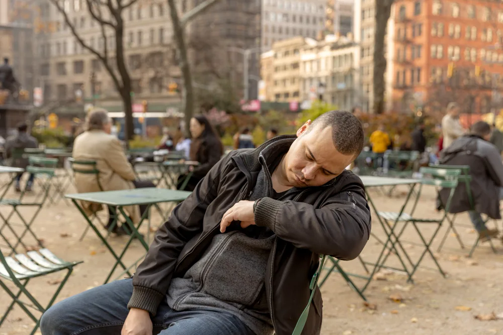 Man looking distressed in a public setting while trying to manage sudden panic symptoms