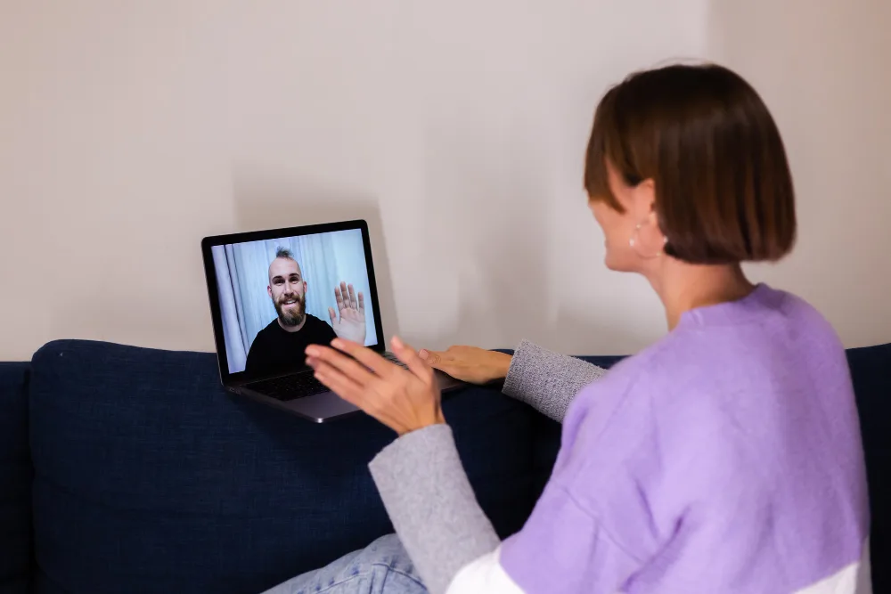 Adult participating in a virtual mental health follow-up while reviewing treatment progress