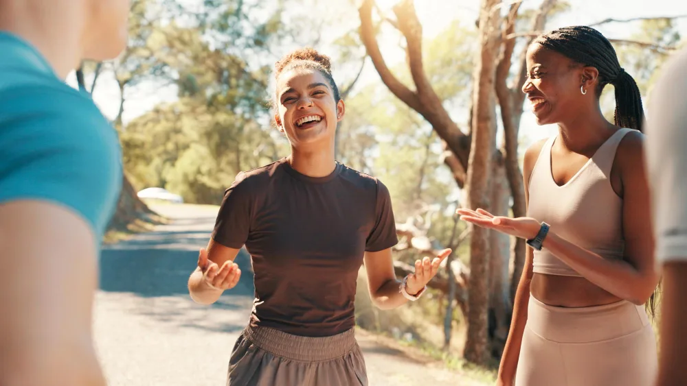 Supportive outdoor wellness conversation exploring sustainable stress management and personal priorities